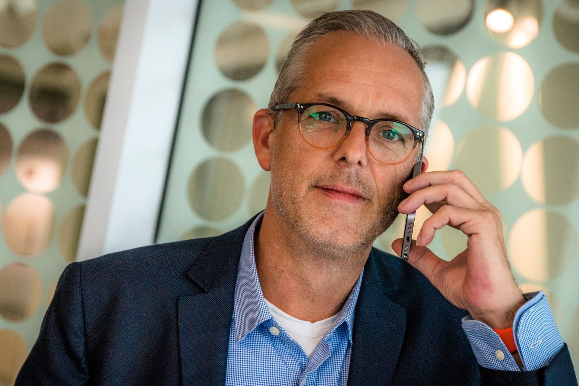 Android Support man wearing glasses holding smartphone to his ear listening