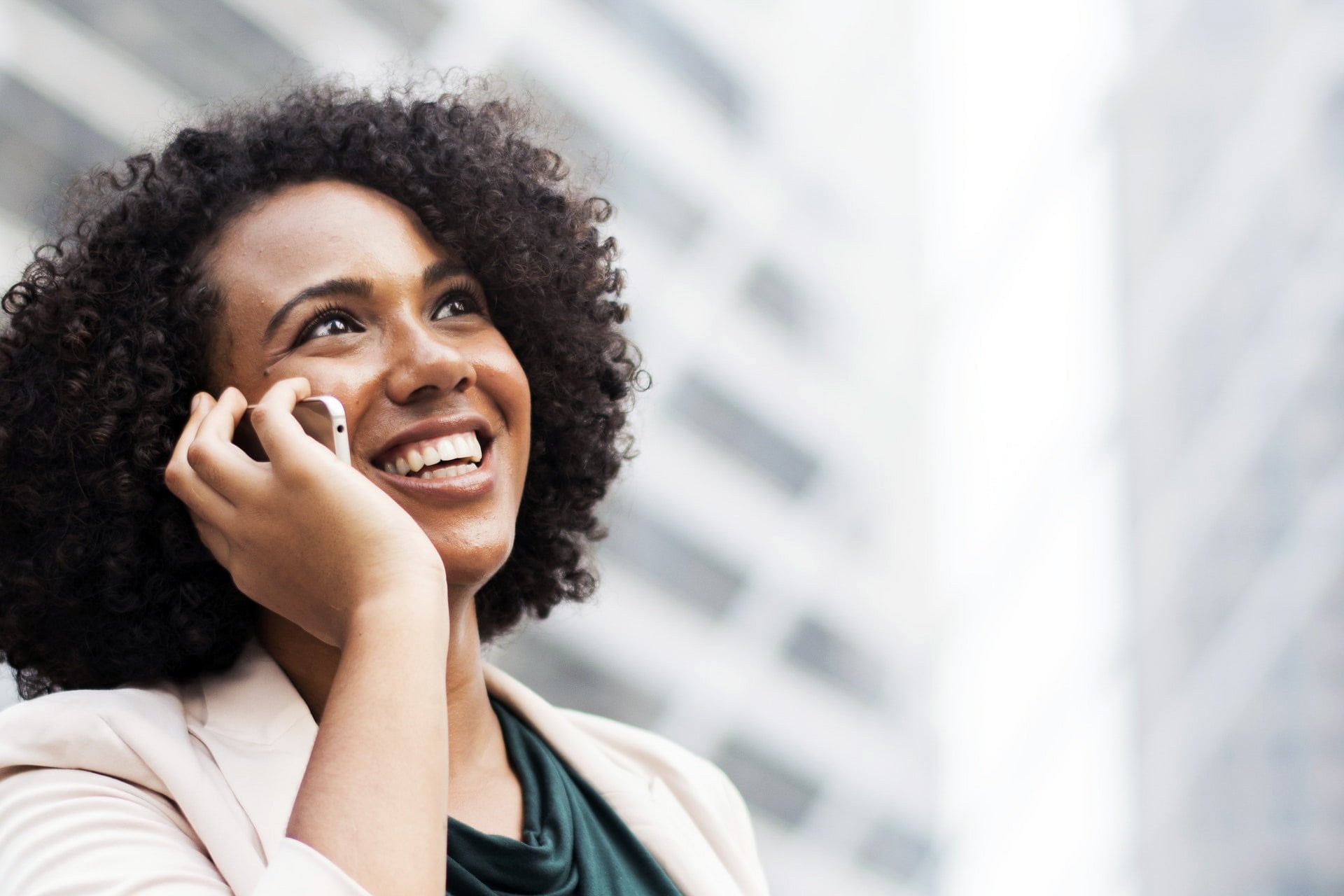 App Support smiling female talking on the phone in the city