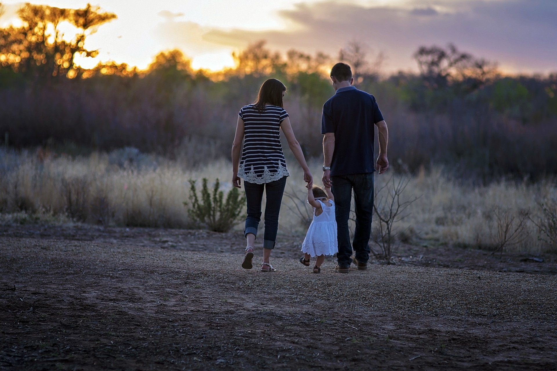Starkey Young Family Mother and father walking with young daughter in a field